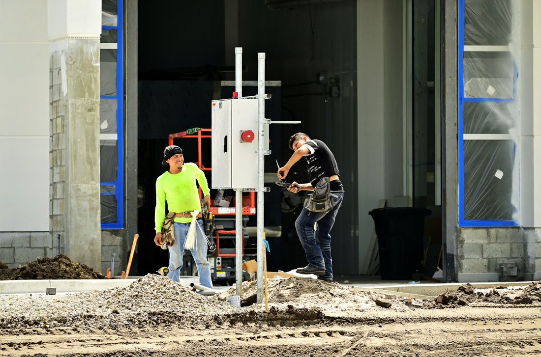 Dos operarios montando un tablero eléctrico en obra